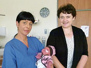 Die kleine Magdalena auf dem Arm von Kinderkrankenschwester Vicky Teller trägt Kleidung, die Veronika Schmitt (rechts) genäht hat.