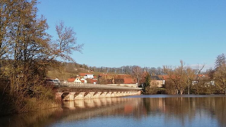 Von Hausen kommend, ist das der Blick auf die Saaleflutbrücke bei Kleinbrach, dahinter ist auch der Ort zu sehen. Sie ist denkmalgeschützt.