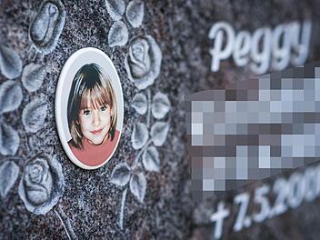 Ein Gedenkstein mit dem Porträt des Mädchens Peggy auf dem Friedhof in Nordhalben. Foto: David Ebener/dpa