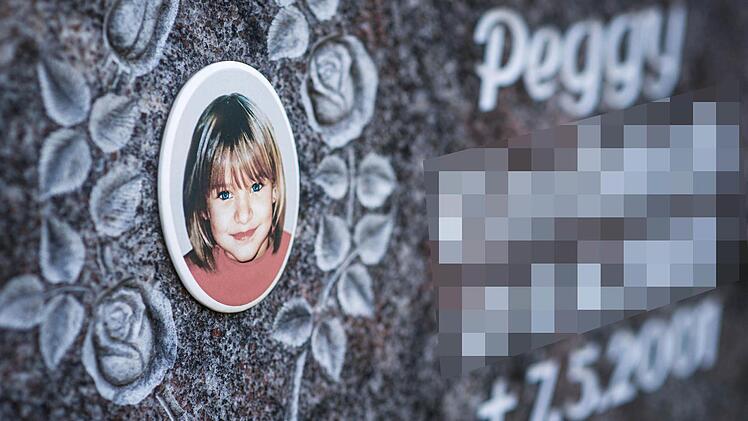 Ein Gedenkstein mit dem Porträt des Mädchens Peggy auf dem Friedhof in Nordhalben. Foto: David Ebener/dpa