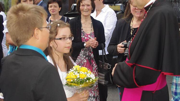 Der Erzbischof (rechts) wurde von den diesjährigen Kommunionkindern willkommen geheißen.