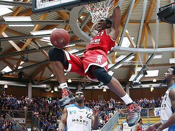 Mit diesem wuchtigen Dunking machte Bambergs Topwerfer Trevor Mbakwe (19 Punkte) den Hunderter für die Brose Baskets voll. Die Crailsheimer Stevie Johnson (l.) und Josten Crow sind machtlos. Fotos: Daniel Löb