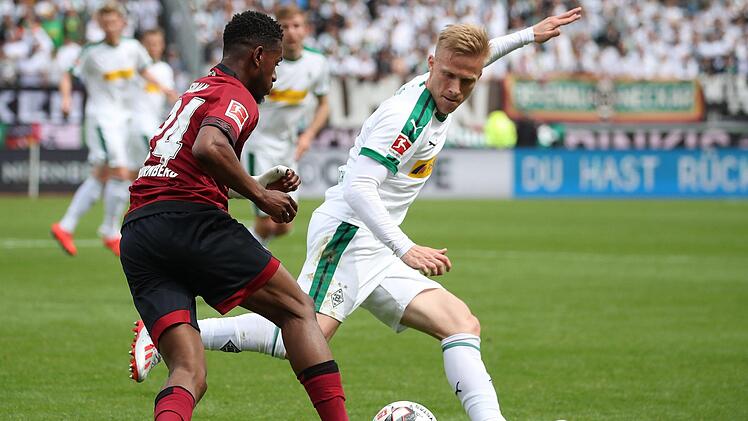 1. FC Nürnberg - Borussia Mönchengladbach, 33. Spieltag im Max-Morlock-Stadion. Der Nürnberger Virgil Misidjan (l) kämpft mit Oscar Wendt von Borussia Mönchengladbach um den Ball. Foto: Daniel Karmann/dpa -