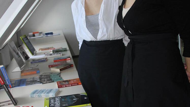 Keana Wongsa und Natalia Wrzeshiowaska schauen sich die ausgewählten Bücher zum Thema