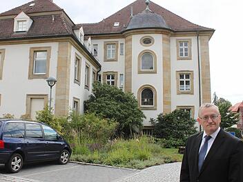 Ein Mann, ein Haus und viele Menschen im Hintergrund: Bezirksheimatpfleger Günter Dippold erforscht die Geschichte des Lichtenfelser Landratsamtes und die prägenden Persönlichkeiten, die dort tätig waren. Foto: Popp