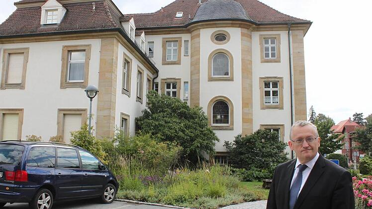 Ein Mann, ein Haus und viele Menschen im Hintergrund: Bezirksheimatpfleger Günter Dippold erforscht die Geschichte des Lichtenfelser Landratsamtes und die prägenden Persönlichkeiten, die dort tätig waren. Foto: Popp