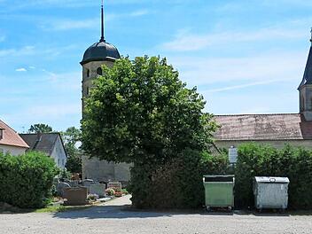 Auf dem Parkplatz wird neben der Hecke, die den Friedhof in Poxdorf abschließt, die Aussegnungshalle gebaut werden.  Foto: Dagmar Niemann