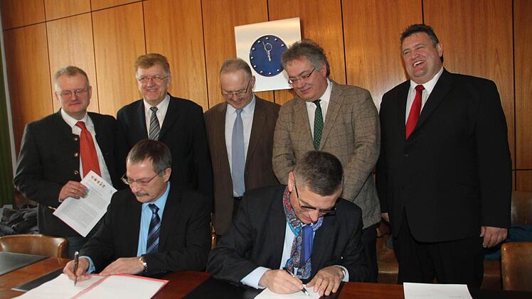 Die Bürgermeister von Bad Berneck und Neuenmarkt, Jürgen Zinnert (links) und Siegfried Decker, unterzeichnen die Urkunde für die Erstellung eines gemeinsamen Energiekonzepts. Mit im Bild (hinten, von links) Wolfgang Böhm von der Energieagentur Nordbayern, Goldkronachs Bürgermeister Günter Exner, sein Marktschorgaster Kollege Hans Tischhöfer, Hans Rainer Albart vom Amt für ländliche Entwicklung in Bamberg und Himmelkrons Bürgermeister Gerhard Schneider. Foto: Jürgen Gärtner