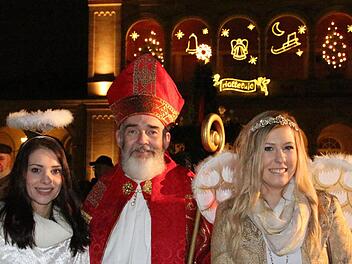 Engelchen Anna-Lena Koch (links) und Franziska Dees mit Nikolaus Udo Dickhage im beleuchteten Kurpark. Foto: Benedikt Borst