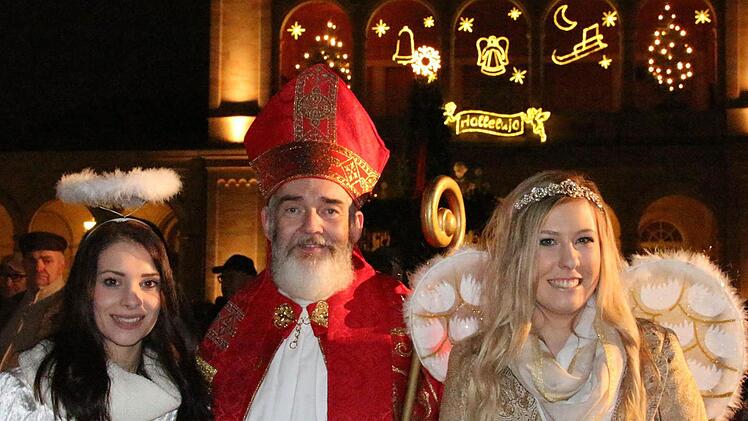 Engelchen Anna-Lena Koch (links) und Franziska Dees mit Nikolaus Udo Dickhage im beleuchteten Kurpark. Foto: Benedikt Borst