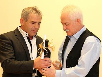 Bürgermeister Ludwig Nagel überreicht einen guten Tropfen mit Geschenkkuvert. Foto: Johanna Blum