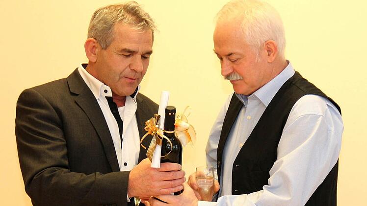 Bürgermeister Ludwig Nagel überreicht einen guten Tropfen mit Geschenkkuvert. Foto: Johanna Blum