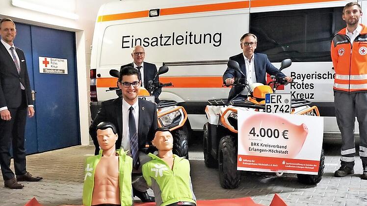 Symbolische Scheckübergabe beim BRK für Kleinfahrzeuge, Rettungsmatten und Erste-Hilfe-Übungspuppen (v. l.): Thomas Pickel und Johannes von Hebel (Stadt- und Kreissparkasse Erlangen-Höchstadt-Herzogenaurach), Landrat Alexander Tritthart, Julian Pertek und (vorne) Alexander Pauls (BRK Erlangen-Höchstadt)