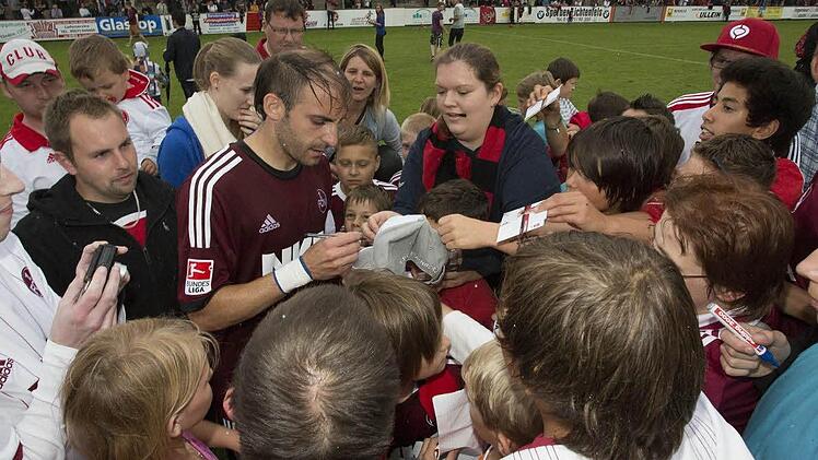 Geduldig schrieben nach dem Abpfiff die FCN-Profis, wie hier Javier Pinola, Autogramm für die Fans. Foto: Uwe Gick