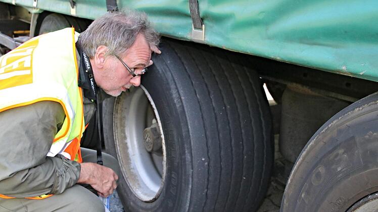 POK Seufert von der Polizei-Inspektion Ebern wird einen kritischen Blick auf Reifen, Aufhängungen und Bremsen an einem Lkw.Helmut  Will