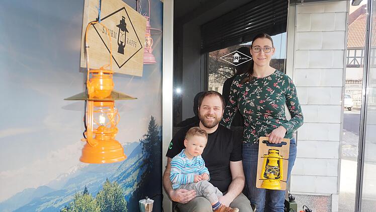 Familie Schmidt aus Fladungen hat ein Faible für Camping. Sie haben für die klassische Petroleumlampe einen Lampenschirm entwickelt. Im Schaufenster in Fladungen und im Internet präsentieren  sie ihr Sortiment. Das Bild zeigt Benedikt und Linda Schmidt mit Söhnchen Oliver. Foto: Marion Eckert