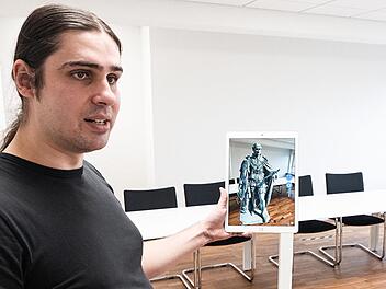 Mit der Kamera des Tablets erfasst Daniel Schneider von der Hochschule Coburg den Raum und kann dabei virtuell Objekte wie das Albertdenkmal platzieren.  Foto: Julian Uebe, Hochschule Coburg