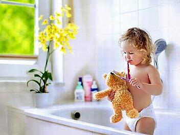 Johanna will unbedingt dem Bären die Zähne putzen - im kindgerechten Bad ist das kein Problem.  Foto: Vereinigung Deutsche Sanitärwirtschaft (VDS) / Shutterstock / FamVeld