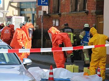 Ein Feuerwehrmann reinigt die Chemieschutzanzüge zweier Kollegen am Dienstag nach dem Einsatz in dem von Ammoniakgas verseuchten Keller.