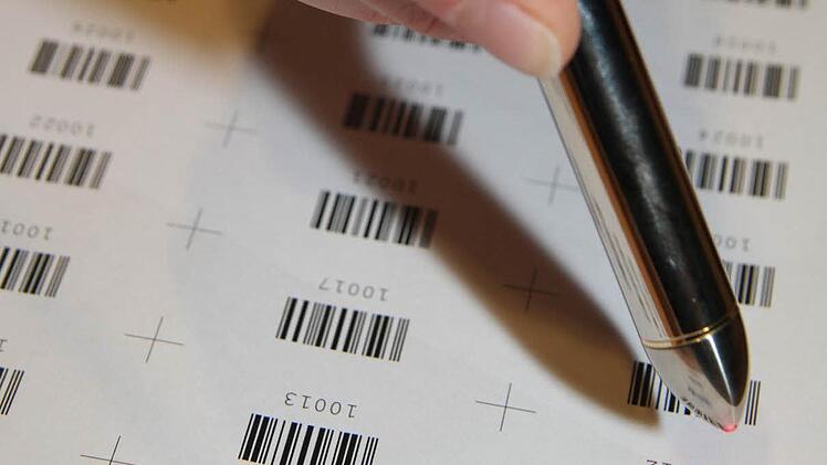 Jeder Wahlschein wird mit einem Stimmzettelaufkleber versehen - und dieser wird dann gescannt, erst dann können die Stimmen ausgezählt werden