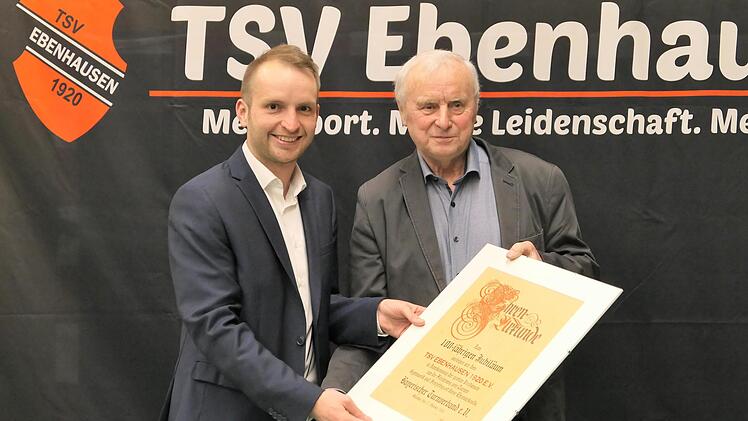 Günter Dietz, Bezirksvorsitzender von Unterfranken des Bayerischen Turnverbandes (links), übergibt Sebastian Dees, dem Vorsitzenden Öffentlichkeitsarbeit des TSV Ebenhausen die Urkunde zum 100. Vereinsgeburtstag