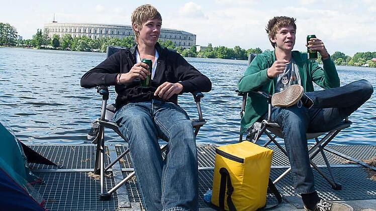 Zwei Besucher chillen am Wasser - gut ausger&uuml;stet mit Bier, K&uuml;hltasche und St&uuml;hlen.