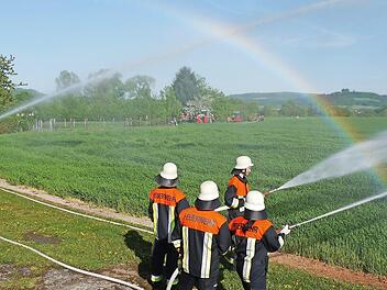 Löschen unterm Regenbogen: Die Zusammenarbeit der Feuerwehren - wie hier mit Ober- und Unterbrunn an der Spritze - war bei der ersten Übung der Alarmierungseinheit vorbildlich. Fotos: Berthold Köhler