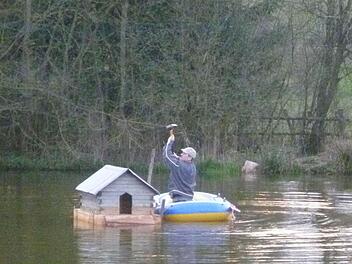 Auf dem Schlauchboot installierte Stefan Selbert das sanierte Entenhäuschen. Foto: Alexander Zöller