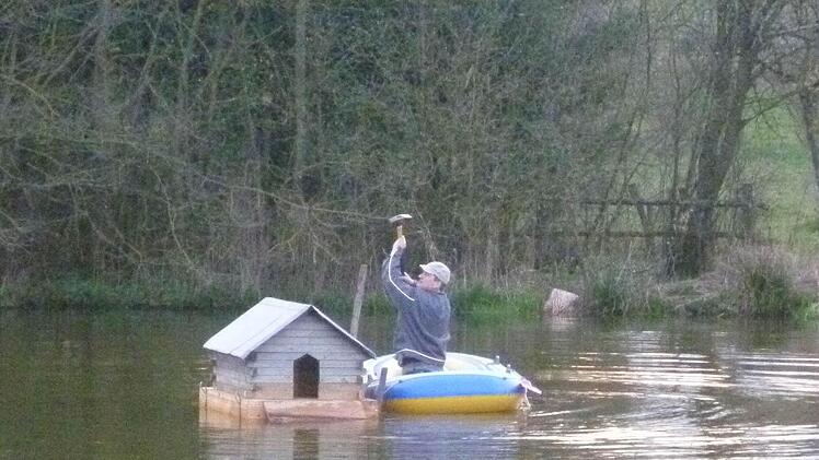Auf dem Schlauchboot installierte Stefan Selbert das sanierte Entenhäuschen. Foto: Alexander Zöller