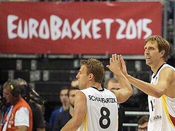 Geschafft: Dirk Nowitzki (rechts) klatscht seinen Kapitän Heiko Schaffartzik ab. Foto: Rainer Jensen/dpa