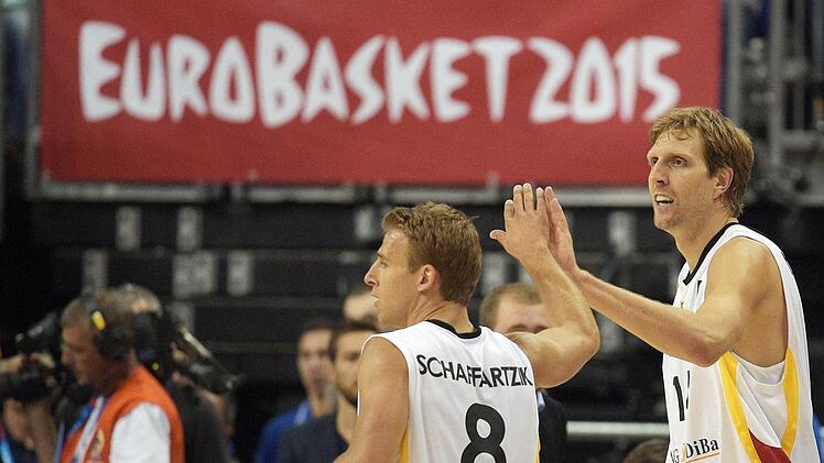 Geschafft: Dirk Nowitzki (rechts) klatscht seinen Kapitän Heiko Schaffartzik ab. Foto: Rainer Jensen/dpa