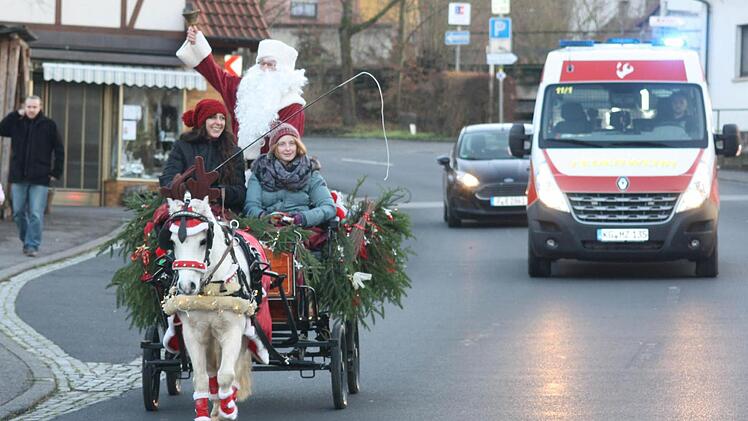 Ankunft des Weihnachtsmannes in der Kutsche - aus Sicherheitsgründen begleitet von einem Einsatzfahrzeug der Freiwilligen Feuerwehr. Foto: Joachim Weichert