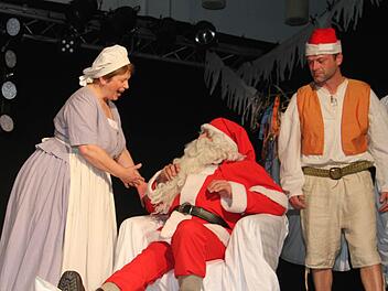 Frau Holle (Gabi Olbrich) ist untröstlich: Der Weihnachtsmann (Eberhard Einwag) ist auf einem Pfund Butter, das auf dem Fußboden lag, ausgerutscht - und kann die Geschenke nicht ausliefern. Doch Hans im Glück (Thomas Märkl) kann helfen. Foto: Sonja Adam