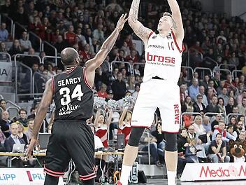 Daniel Theis lässt es nicht nur unter dem Korb krachen, er hat auch ein lockeres Händchen. Hier wirft er aus der Halbdistanz über den Würzburger Devin Searcy hinweg. Foto: sportpress
