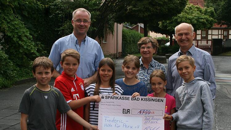 Scheckübergabe durch Rektor Bernd Czelustek (hinten links) und die Klassensprecher der dritten Klassen an Francoise und Gerhard Wielgoss. Foto: Dieter Six