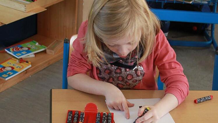 Theresa malt gerade an einer Lernstation im Klassenzimmer den Buchstaben "T" nach.  Foto: Lisa Kieslinger
