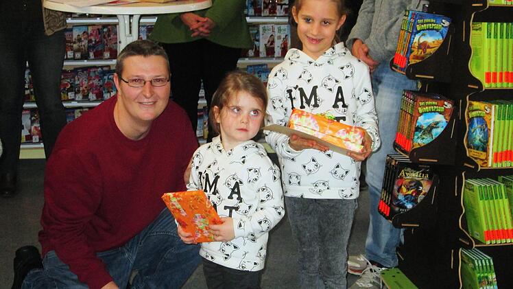 Bücherteamleiter Heiko Frank übergab den jüngsten "Mitarbeitern, Mona und Maya Frank ein Präsent für das Einscannen von rund 3 000 Medien. Foto: Winfried Ehling