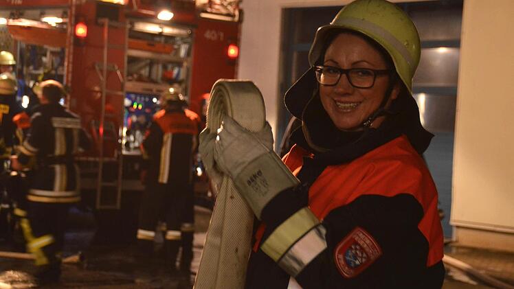 Isabell Albert leistet erst seit Kurzem Dienst bei der Feuerwehr Bu-Wo-Za. Hier hilft sie beim Aufrollen der Schläuche, während die Kameraden im Hintergrund ihr Einsatzfahrzeug beladen. Foto: Kathrin Kupka-Hahn