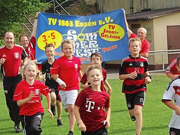 Laufen für einen guten Zweck: Vom 3. Bis 5. Juli steigt das Sommerfest des TV Ebern. Am Sonntag findet für Erwachsenen und Kinder ein Spendenlauf statt. Das Startgeld ist frei wählbar. Eine Anmeldung ist nicht erforderlich. Die Fußball-Kids laufen sich bereits heute schon mit ihren Trainern Frank Ziegler (links), Eckart Roeß (Zweiter von links) und Edi Schneider (rechts) warm. Foto: Johanna Eckert