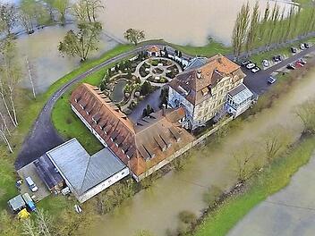 Mitunter mehrfach im Jahr wird das Denkmal an der Itz zum Wasserschloss, wie heuer im Februar (im Bild noch ohne Aufdach). Schlimm war es 2003, als "wir kurz vor einer Evakuierung standen, da das Wasser den Heizungsraum zu überschwemmen drohte und wir die Sandsäcke nur so schleppten", erinnert sich Peter Uhlig. Deutlich zu erkennen sind die Anbauten und der später an gelegte Park für alle Heimbewohner, wo Strandkörbe im Sommer einen Hinweis auf die Eigentümer geben. Sie stammen aus Bremen.  L...