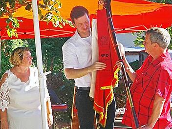 Bettina John (links) und Alexander Orleth (rechts) überraschten Gemeinderat Stumpf mit einem Fahnenband.