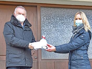 Bürgermeisterin Elisabeth Simmerlein übergibt Geschenke und Masken an den 71-jährigen Erich Langenfelder.  Foto: Karl Heinz Wirth