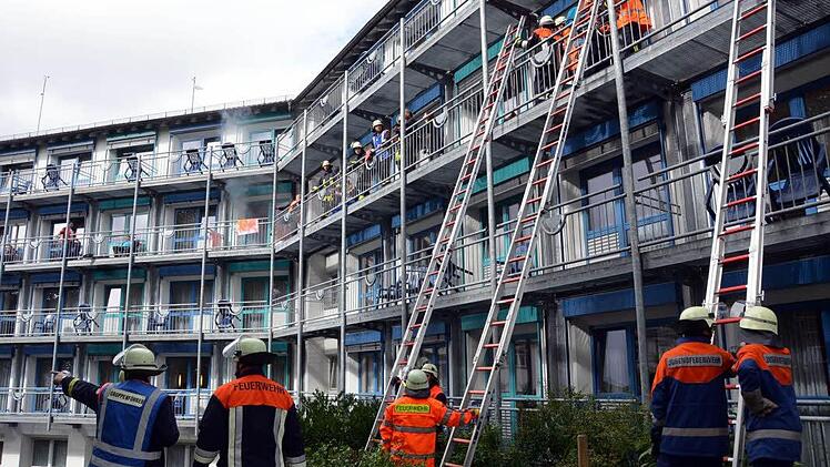 Handarbeit gefragt: Wegen der engen Verhältnisse und der zum Teil körperlich eingeschränkten "Patienten" konnten diese nur über Steckleitern aus dem Gebäude gerettet werden.  Fotos: Peter Rauch
