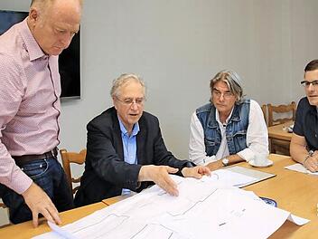 Architekt Dag Schröder zeigt Bürgermeister Helmut Blank (links), Statiker Peter Wolf (2. von rechts) und Bauamtsleiter Simon Glückert anhand der Pläne, in welchen Schritten der Abriss des Hallenbades geplant ist. Foto: Heike Beuert