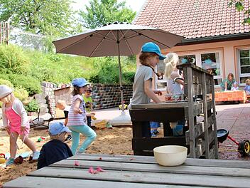 Bei sonnigem Wetter macht das Spielen im Freien richtig Spaß: Ella kocht soeben Suppe. Die großen Kastanien spenden dabei ausreichend Schatten. Mit dem Kita-Neubau wird die Spielfläche allerdings kleiner. Deshalb wird ein Stück des Nachbargrundstücks gebraucht.  Foto: Kathrin Kupka-Hahn
