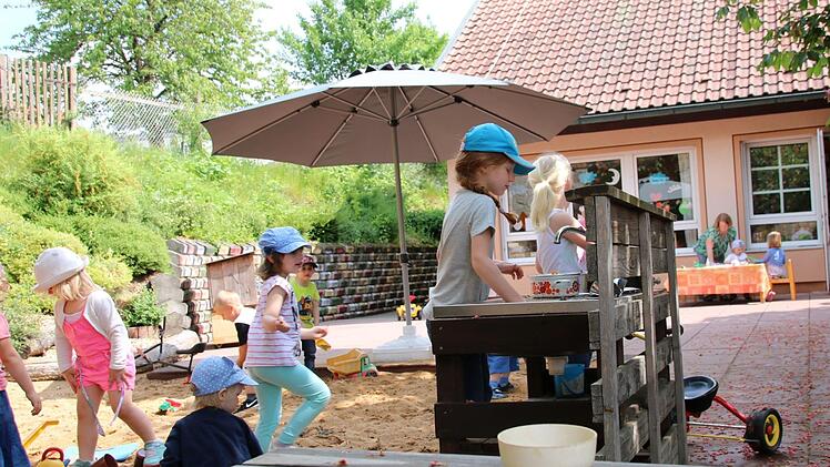Bei sonnigem Wetter macht das Spielen im Freien richtig Spaß: Ella kocht soeben Suppe. Die großen Kastanien spenden dabei ausreichend Schatten. Mit dem Kita-Neubau wird die Spielfläche allerdings kleiner. Deshalb wird ein Stück des Nachbargrundstücks gebraucht.  Foto: Kathrin Kupka-Hahn