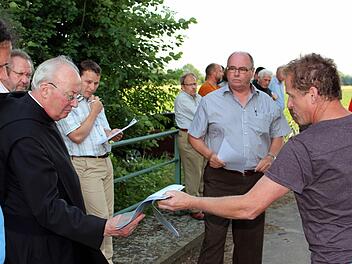 Überflutete Äcker: Interessiert nimmt Pater Franziskus Büll die Lichtbildaufnahmen vom jüngsten Hochwasser von Landwirt Lorenz Bremer entgegen. Foto: Pfannes