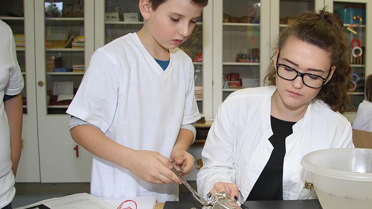 Jannik Pötschke machte die Probe aufs Exempel und probierte, ob Alufolie brennen kann: "Mir macht das auch Spaß", sagte Jennifer Blum vom Caspar-Vischer-Gymnasium, die die Station mit den Feuerexperimenten leitete. Fotos: Sonja Adam