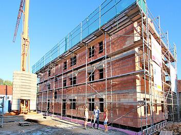 Ein dreistöckiges Haus mit acht Wohnungen entsteht zurzeit in der Hauptstraße 89 in Poppenlauer. Damit wird hier eine wenig schöne Baulücke geschlossen. Unser Bild zeigt im Vordergrund die Bauherren Tanja und Thomas Erdmann mit Tochter Katharina.  Foto: Dieter Britz