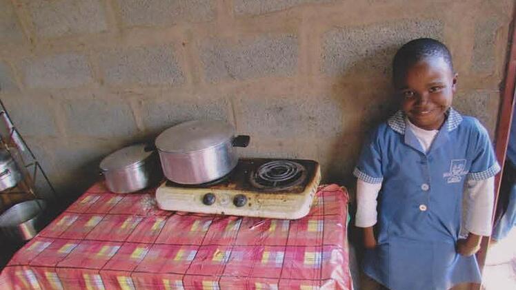 Nolwazi freut sich über ein Topfset, das sie sich dank des Hilfsprojekts "Siyabonga - Helfende Hände für Afrika" kaufen konnte.  Fotos: Realschule Bad Staffelstein